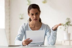 Photo of a woman finding unauthorized credit card charges on her statement depicting when Schlanger Law Group can help