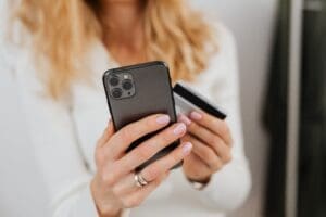 A woman holding a phone and a credit card in her hand seeks lawyer for credit card dispute.