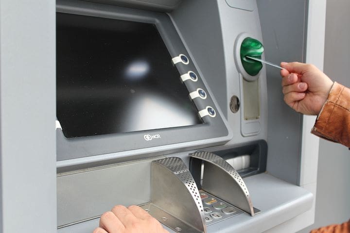 Photo of a person using a debit card at an ATM depicting a situation where a consumer may need an electronic funds transfer act attorney to correct transaction errors.