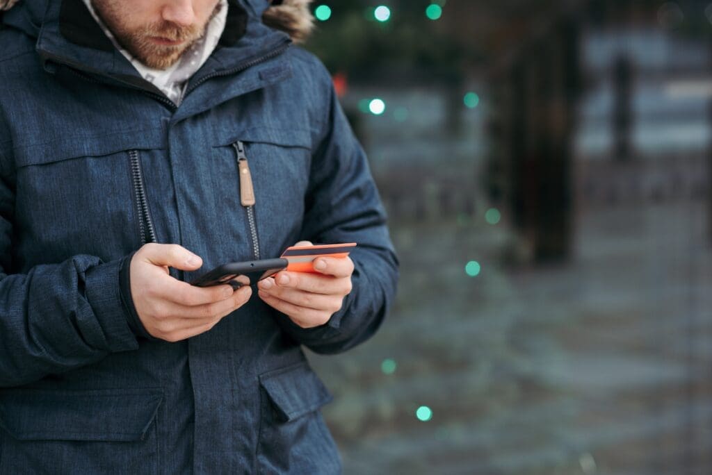 Man using phone and credit card.