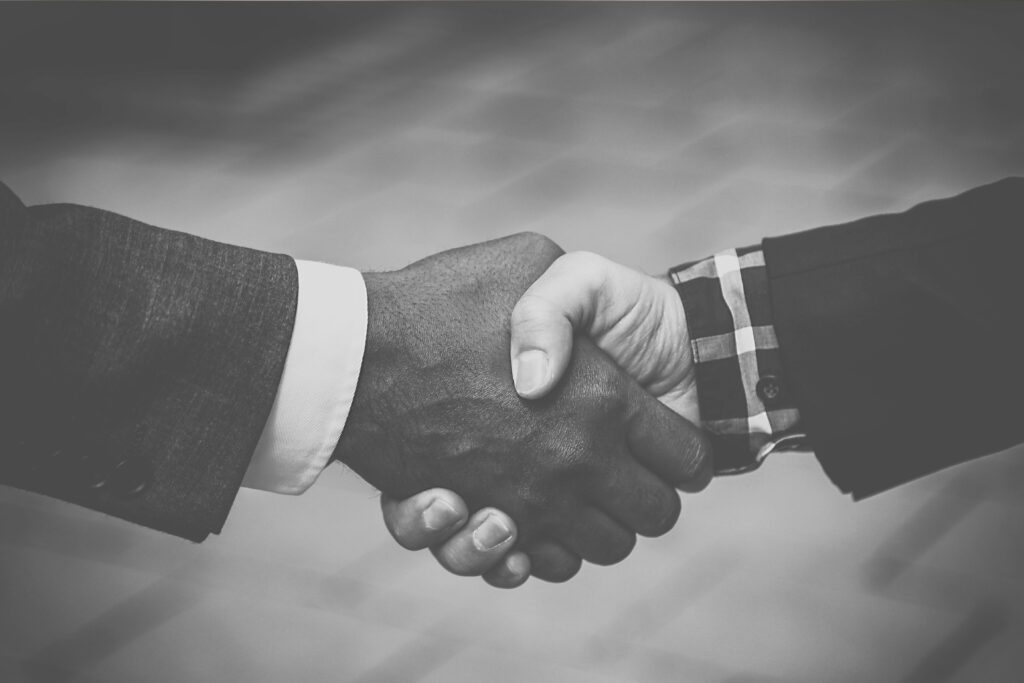 A black and white photo of two business people shaking hands.