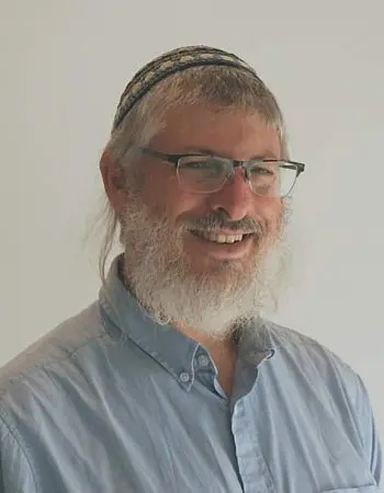 Man with beard and kippah smiling.