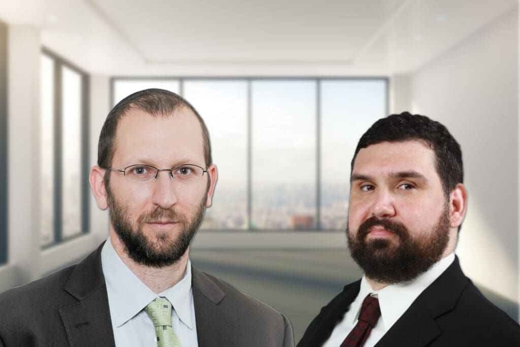 Two men in suits against a blurry background.