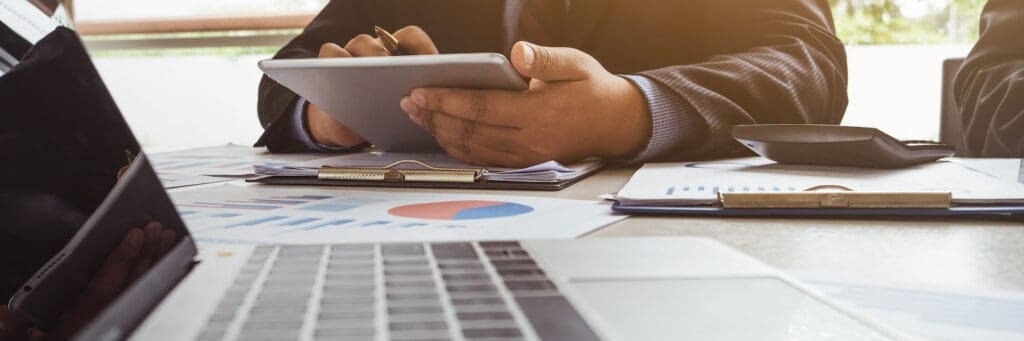 Businessman using tablet and discussing financial data.