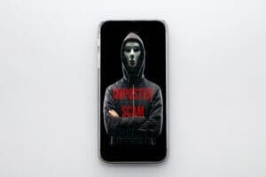 Masked figure on phone, imposter scam warning.